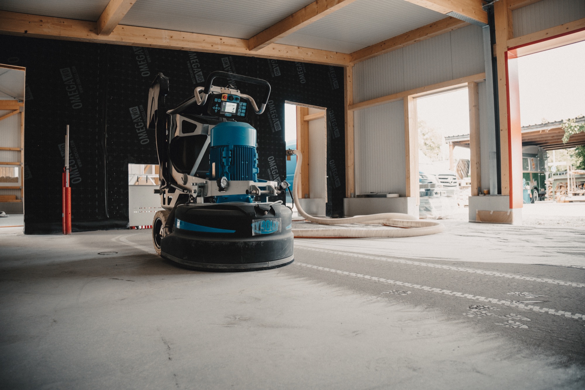 Schleifmaschine in der leeren Halle, Schleifspuren auf dem Boden