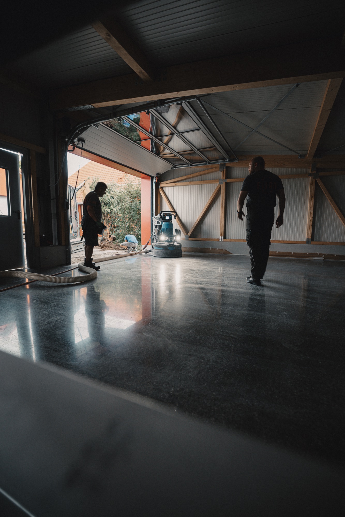 Zwei Fidan Mitarbeiter als Silhouette auf dem spiegelglatten Boden