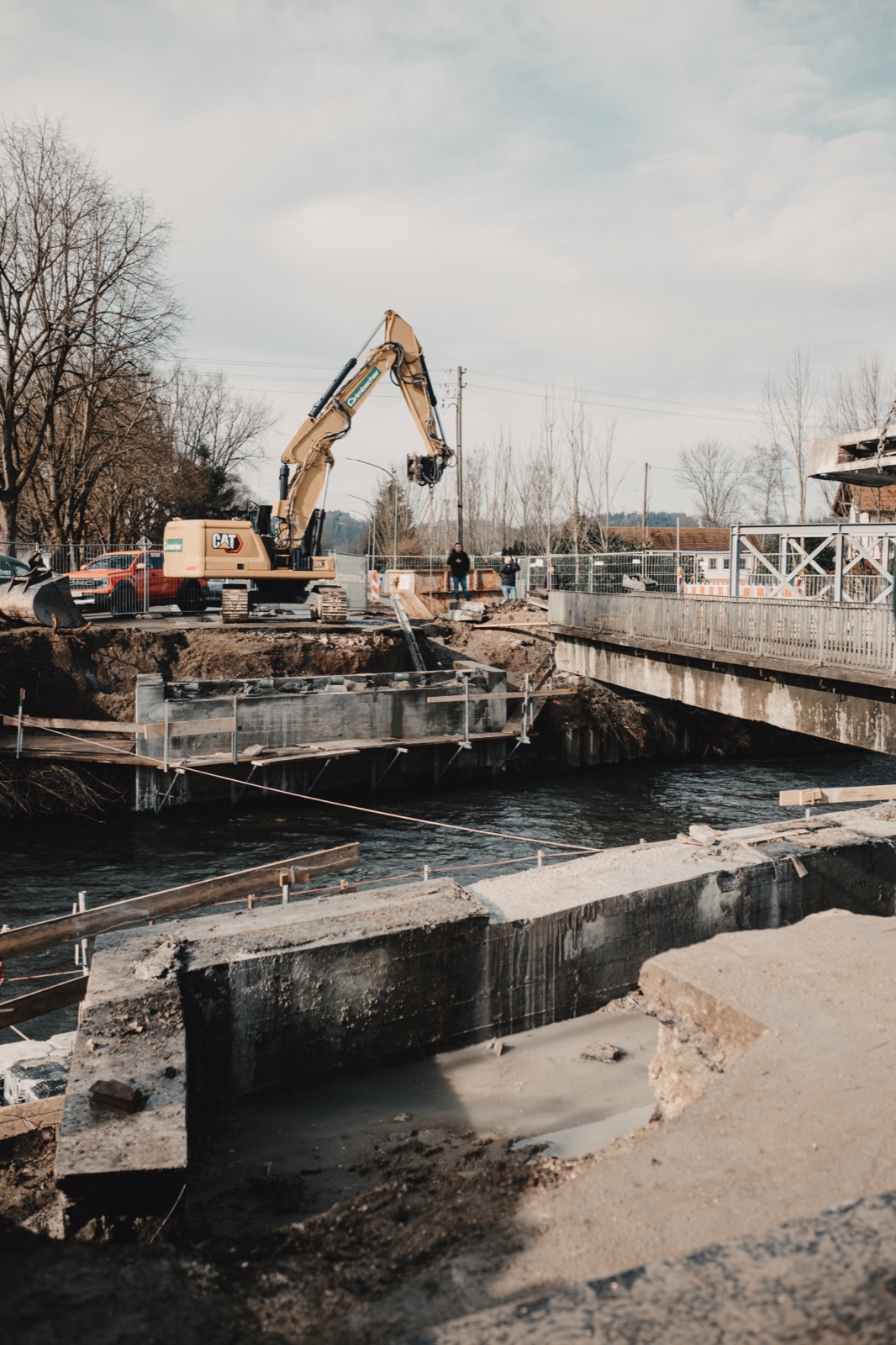 Bagger beim Rückbau der Brückenunterkonstruktion am Flussufer in Jettingen-Scheppach