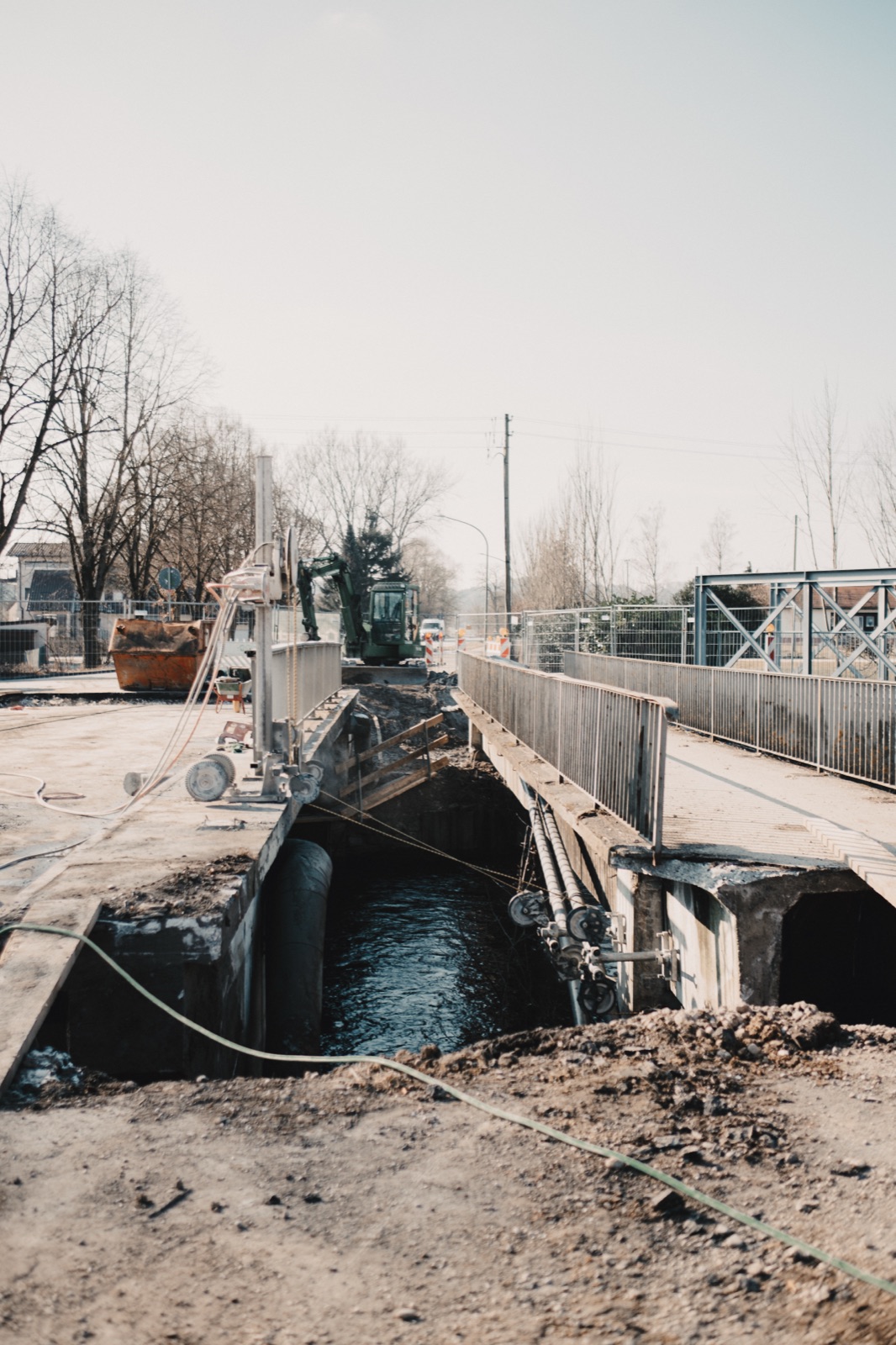 Brücke im Rückbau mit freigelegtem Flussbett und Baumaschinen