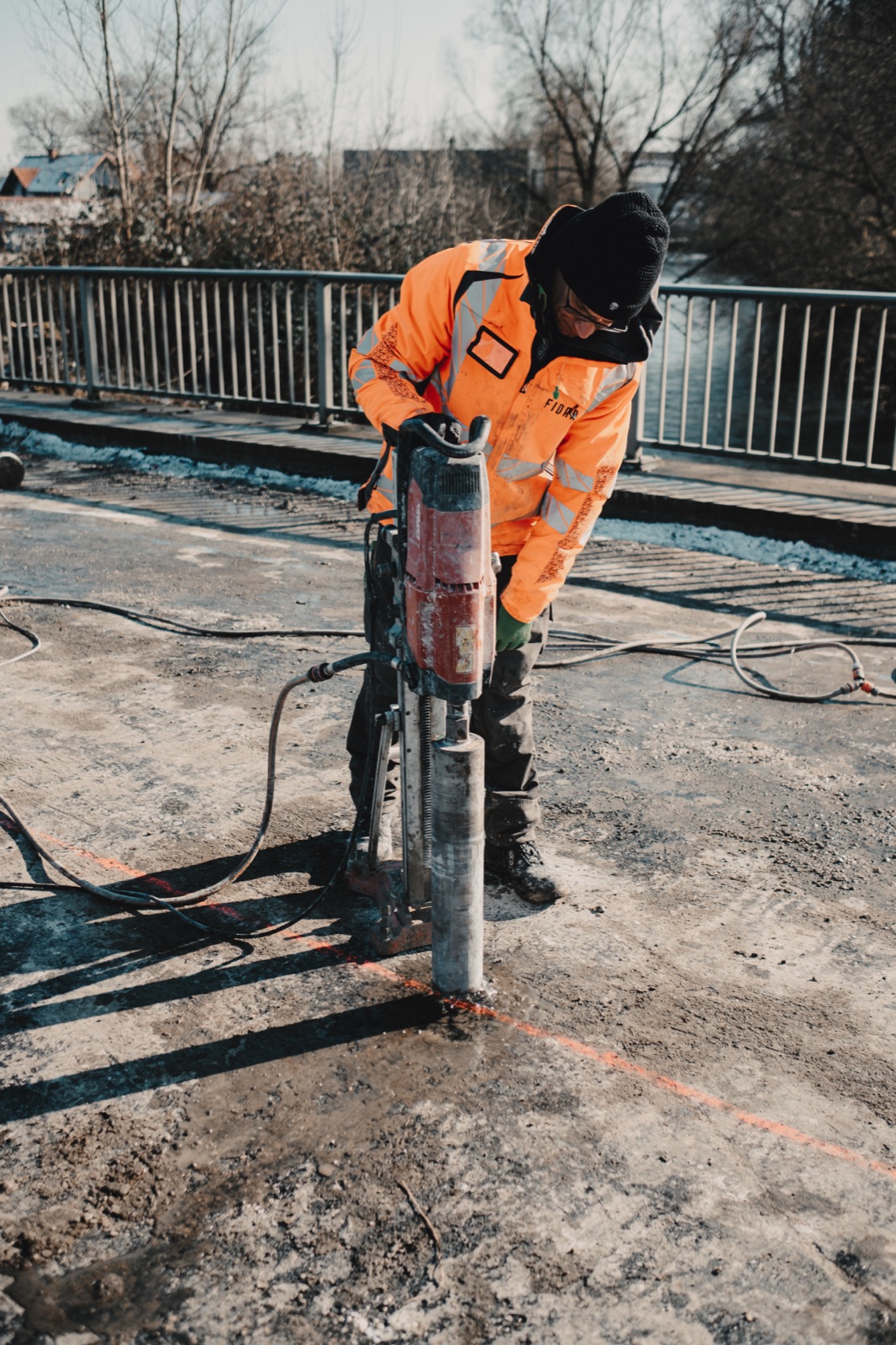 Fidan Monteur bedient Kernbohrmaschine auf der Brückenfahrbahn