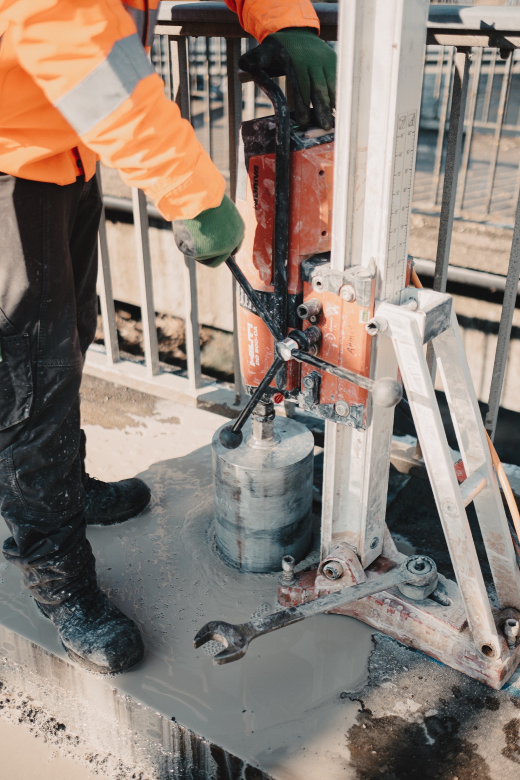 Nahaufnahme der Kernbohrmaschine beim Bohren in die Brückenfahrbahn