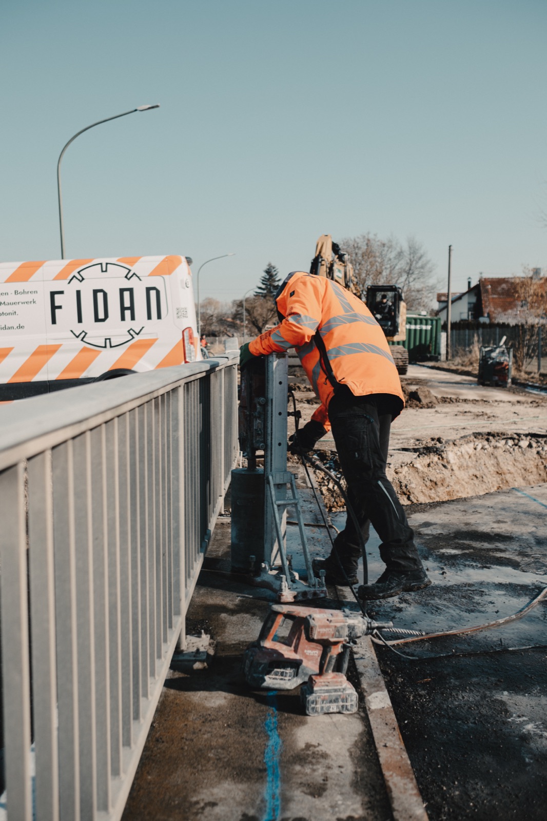 Fidan Monteur bei Kernbohrarbeiten auf der Brücke in Jettingen-Scheppach, im Hintergrund das Fidan-Firmenschild