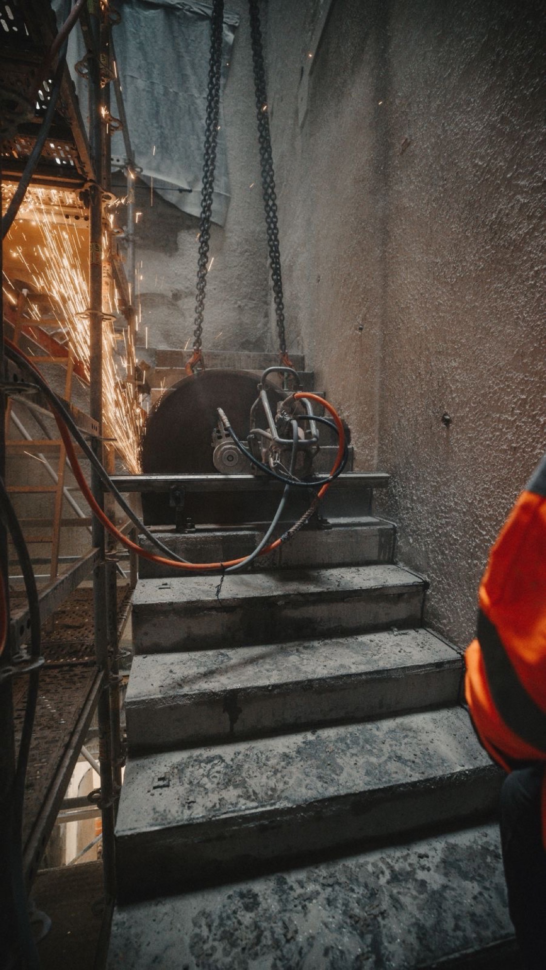 Monteur überwacht den Wandsägeschnitt an der Betontreppe