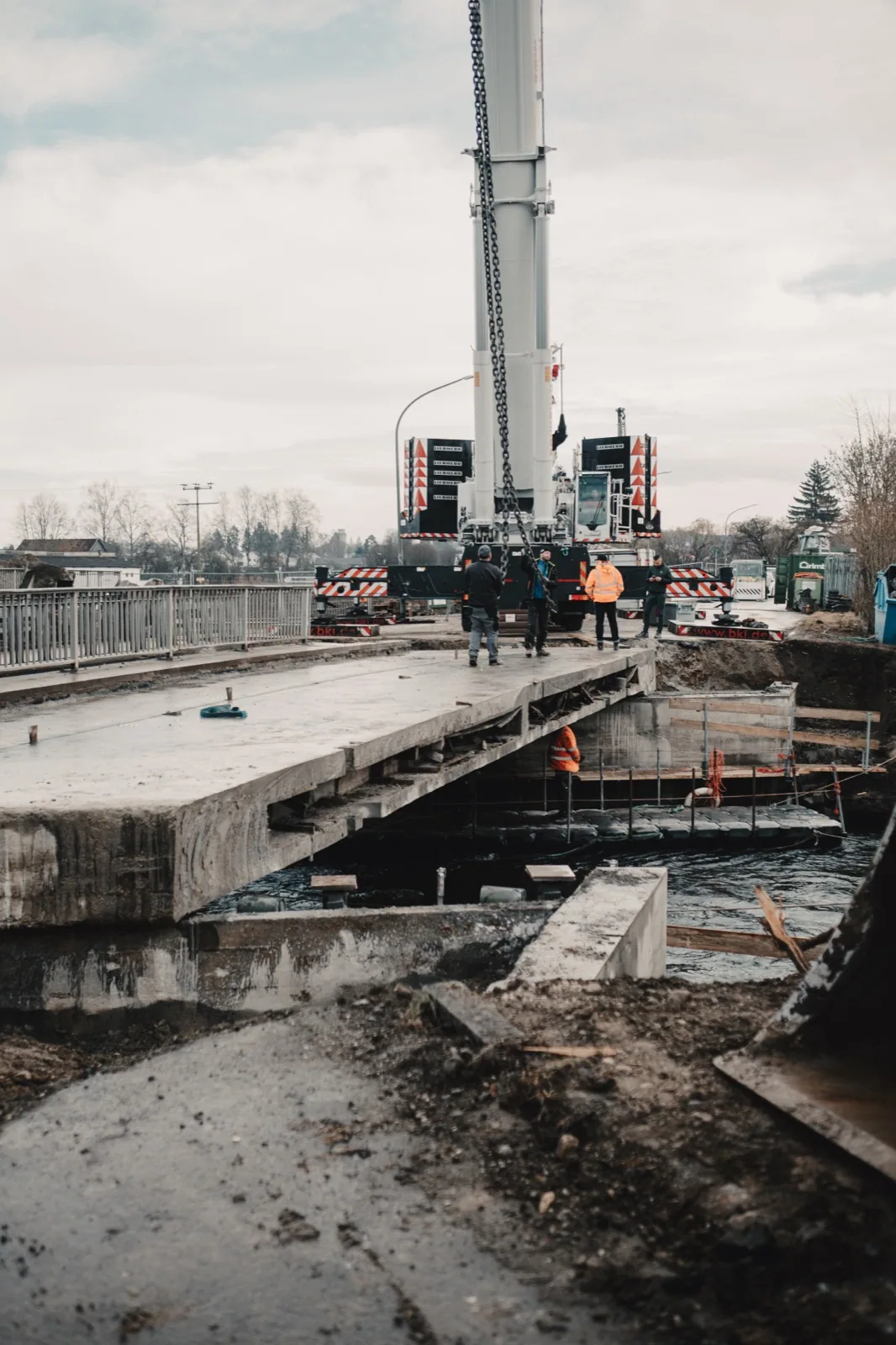 Fidan-Team auf der Brücke in Jettingen-Scheppach, während der Kran ein Betonsegment anhebt